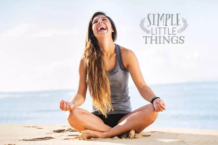 woman on a beach laughing yoga